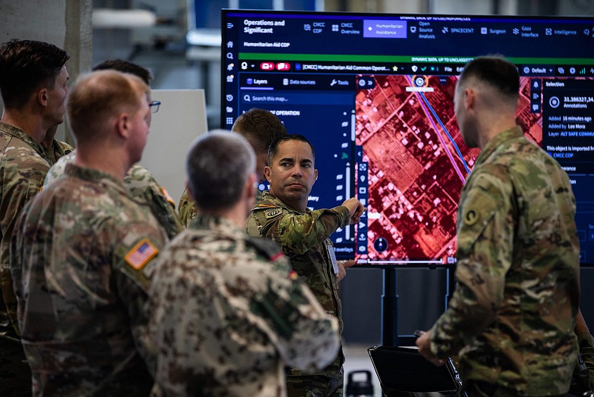 U.S. and German military personnel stand in front of a monitor running Palantir software, at the Civil-Military Coordination Center in Kiryat Gat, southern Israel, on November 12, 2025. (U.S. Army photo by Spc. Aiden Griffitts/Wikimedia Commons)