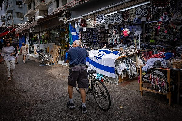 People walk through Tel Aviv’s Carmel Market, partially closed following ongoing missile attacks from Iran, June 23, 2025. (Yonatan Sindel/Flash90)