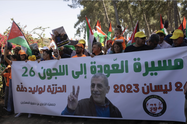 Palestinian citizens of Israel hold a banner bearing the face of Walid Daqqa while taking part in the annual “March of Return” on Israel’s Independence Day, Al-Lajjun, northern Israel, April 26, 2023. (Oren Ziv)
