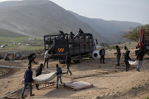 Palestinians pack their belongings into a truck in Ras Ein al-Auja, in the southern Jordan Valley, after Israeli settlers erected an outpost inside the village, January 8, 2026. (Oren Ziv)