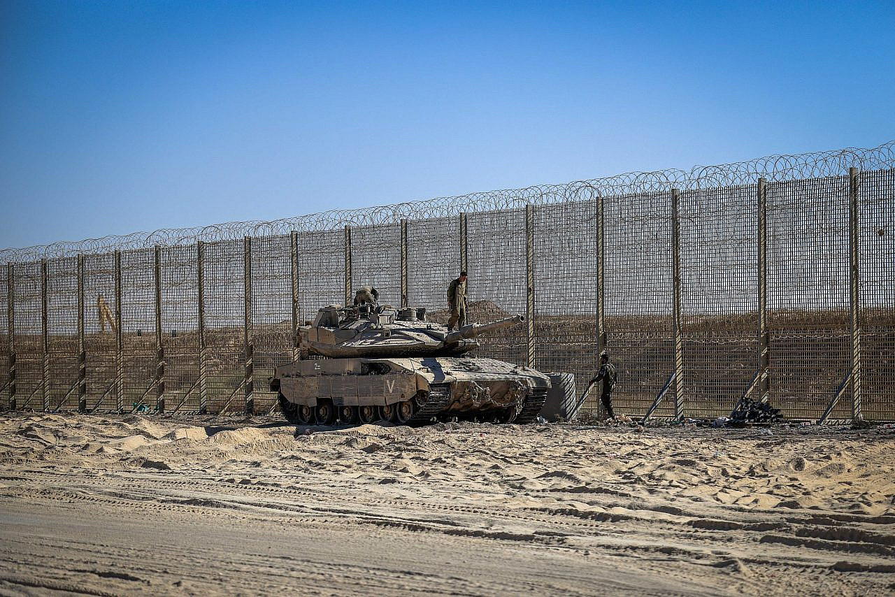 Israeli soldiers stand guard on the Israeli side of the fence surrounding the Gaza Strip, July 4, 2025. (Tsafrir Abayov/Flash90)