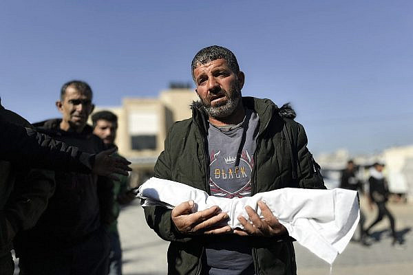 Assad Abdeen carries the body of his one-month-old son, Saeed, who died of cold exposure, in Al-Nasser Hospital in Khan Younis, December 18, 2025. (Doaa Albaz/Activestills)