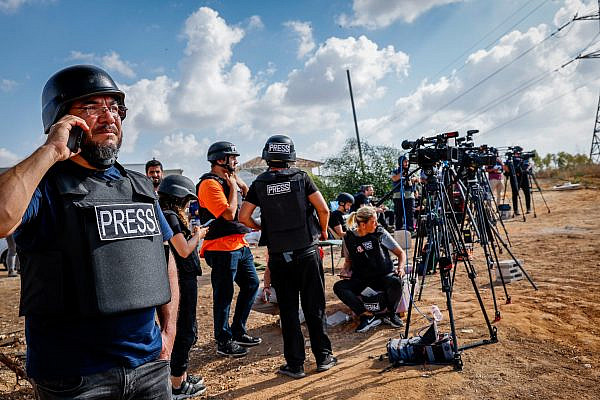 Foreign and Israeli journalists stand on a hill overlooking the Gaza Strip in the city of Sderot, southern Israel, October 19, 2023. (Nati Shohat/Flash90)