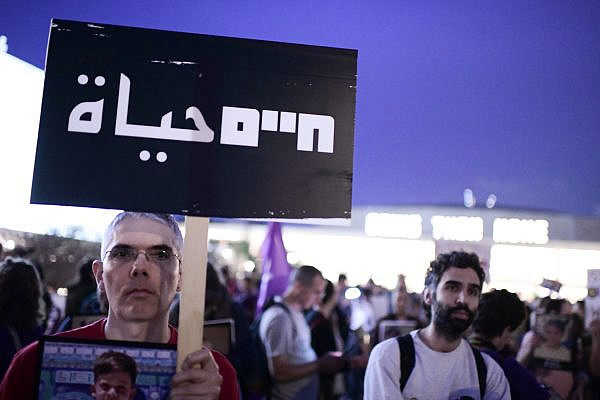A man holds a sign that reads "Life" in both Hebrew and Arabic, during a protest against the war in Gaza, in Tel Aviv, April 24, 2025. (Tomer Neuberg/Flash90)