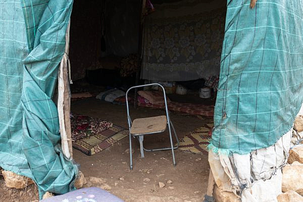 At the entrance of the tent where Israeli settlers gathered and beat residents and activists, in the herding community of Khirbet Humsa in the Jordan Valley, March 13, 2026. (Oren Ziv)