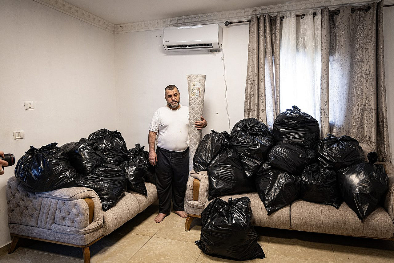 Omar Abu Rajab packs his belongings into trash bags before demolishing his own home to avoid paying high municipal demolition fees, Al-Bustan, Silwan, occupied East Jerusalem. (Faiz Abu Rmeleh)