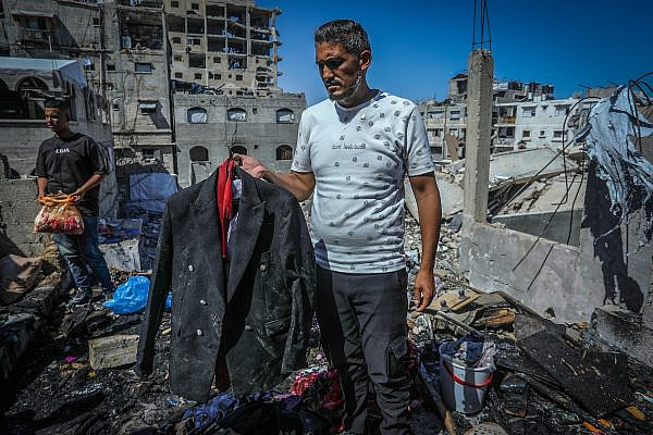 Mohammed Qaddoura holds the wedding suit of his brother-in-law, Mohannad Ferwana, who was killed in an Israeli airstrike the night before his wedding, in Khan Younis, Gaza, June 5, 2026. (Abed Rahim Khatib/Flash90)