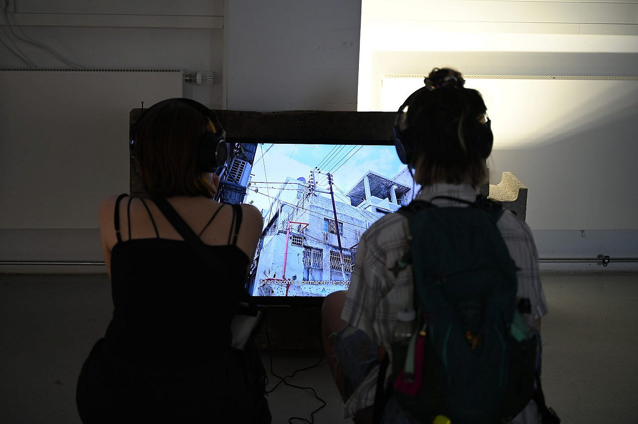 A screen displays artist Dana Qawasmi's 