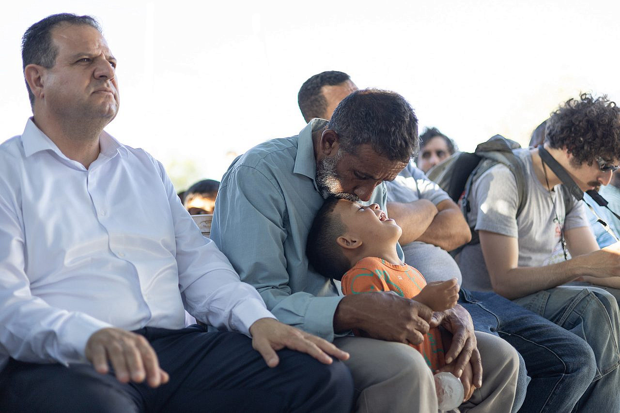 Salem Hathaleen kisses his orphaned nephew Mohammed during the memorial ceremony of his slain father, Awdah Hathaleen. (Omri Eran Vardi)