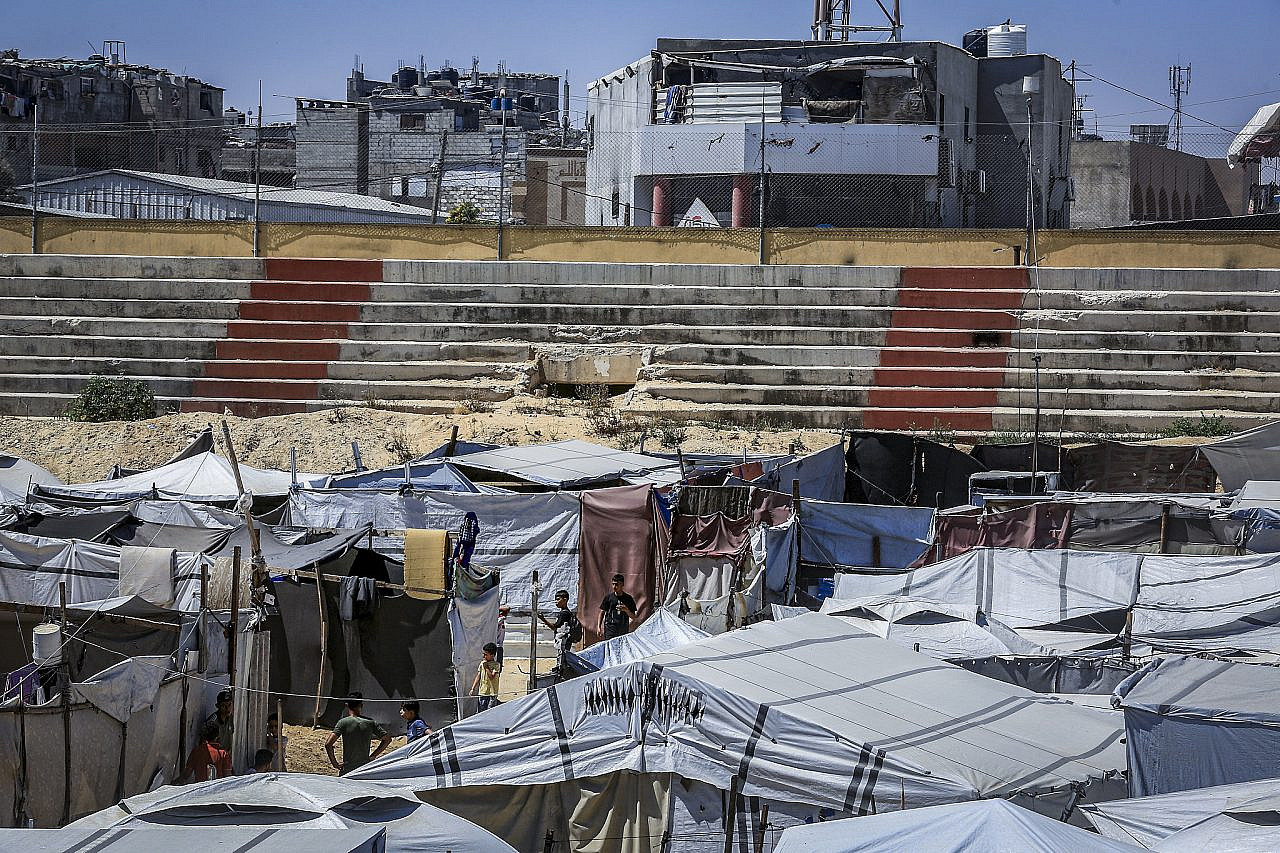 Displaced Palestinians take shelter in a tent camp established inside a football stadium damaged during the recent war in Khan Younis, southern Gaza Strip, June 13, 2026. (Abed Rahim Khatib/Flash90)