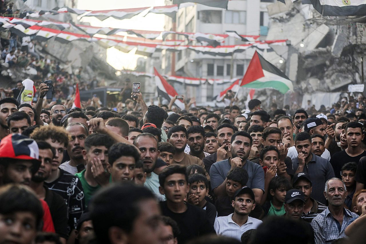 Displaced Palestinians watch the FIFA World Cup match between Egypt and Argentina on a giant screen as they sit among the rubble of destroyed buildings in the center of Gaza City, 7 July 2026. (Yousef Zaanoun/Activestills)