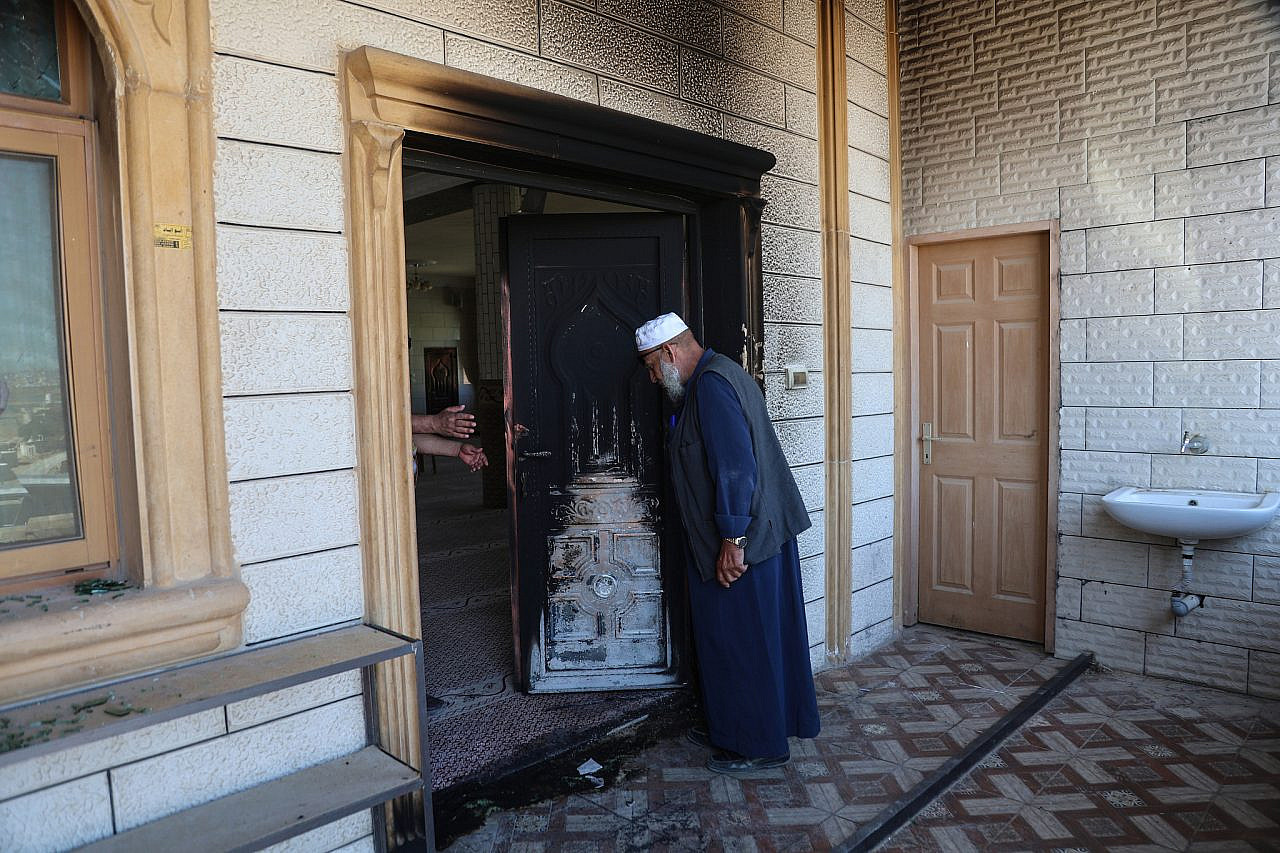 A Palestinian man examines fire damage to a mosque caused by an attack by Israeli settlers the previous night in the village of At-Tuwani, Masafer Yatta, southern occupied West Bank, July 19, 2026. (Mosab Shawer/Activestills)
