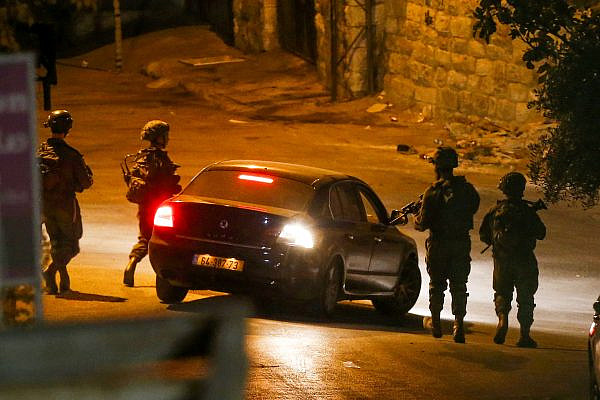 Israeli soldiers inspect a Palestinian car in the West Bank city of Hebron, August 13, 2024. (Wisam Hashlamoun/Flash90)
