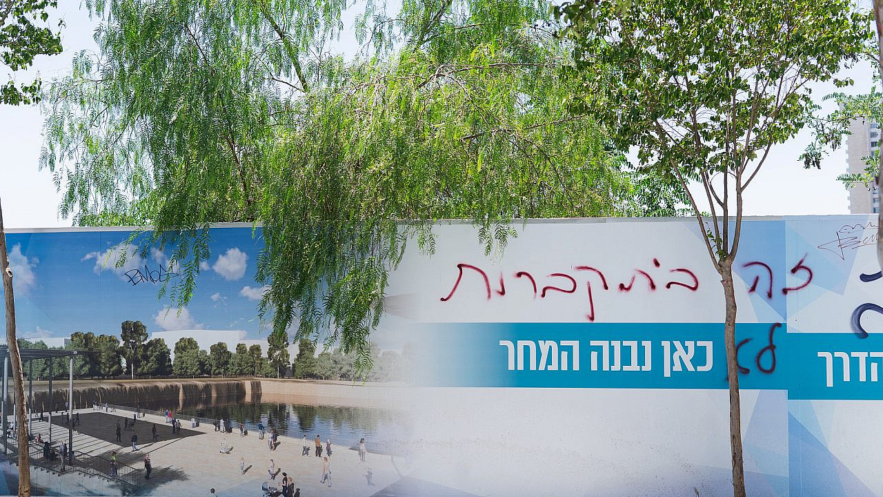 Graffiti in Hebrew reading "This is a cemetery" on a rendering of the Mamilla Pool redevelopment project, as seen on the fence that now surrounds it, Jerusalem. (Timna Rose Perets)