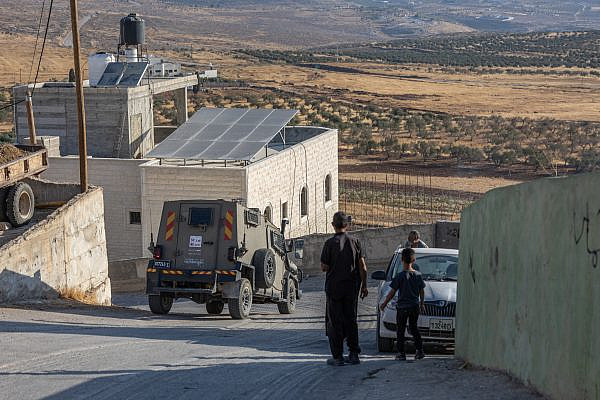 An Israeli military jeep drives through the West Bank village of Al-Mughayyir after an Israeli settler attack in the area, August 11, 2026. (Avishay Mohar/Activestills) An Israeli military jeep drives through the West Bank village of Al-Mughayyir after an Israeli settler attack in the area, August 11, 2026. (Avishay Mohar/Activestills)