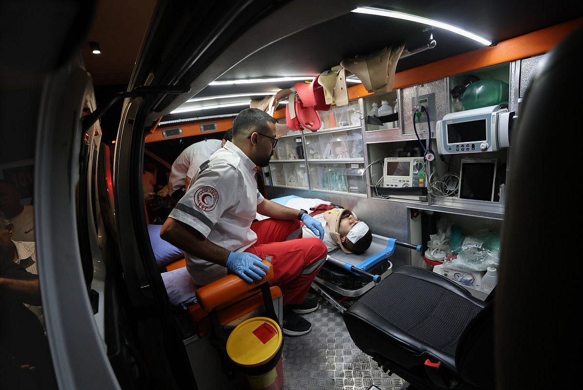 Mohammed Mutafer, a nurse, is treated by medics after Israeli settlers shot and injured him and two other Palestinians during an attack on the town of Sa'ir, east of Hebron (Al-Khalil) in the southern West Bank, August 14, 2026. (Mosab Shawer/Activestills)
