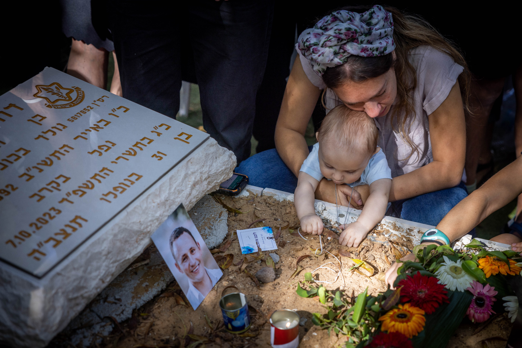 Anat Meir and her baby mourn her husband David Meir, an Israeli soldier killed on October 7 at Kibbutz Be'eri, at Mount Herzl Military Cemetery in Jerusalem, November 8, 2023. (Chaim Goldberg/Flash90)