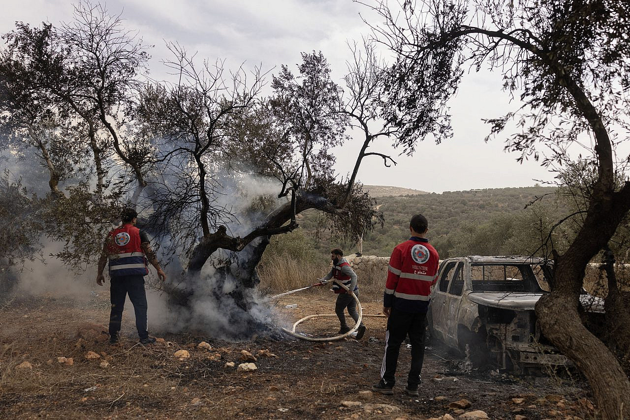 Palestinian firefighters attempt to tackle a blaze set by Israeli settlers in a Palestinian olive grove in Turmus Ayya, occupied West Bank, October 14, 2026. (Oren Ziv)