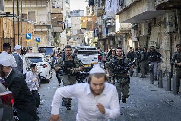 Israeli police officers chase an ultra-Orthodox man during a police operation in the Haredi neighborhood of Mea Shearim, in Jerusalem, October 5, 2026. (Chaim Goldberg/Flash90)