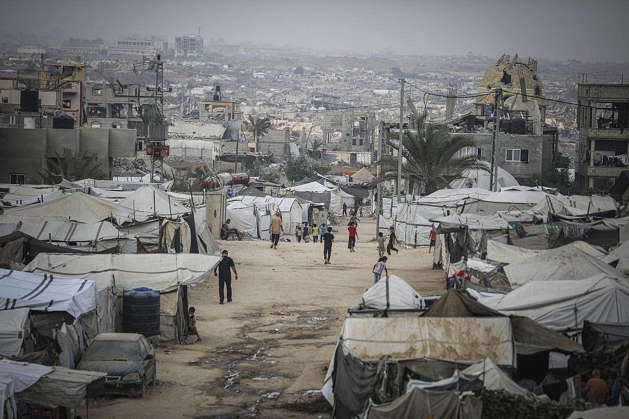 Displaced Palestinians are seen near their tents at a displacement camp in the central Gaza Strip, October 24, 2026. (Ali Hassan/Flash90)