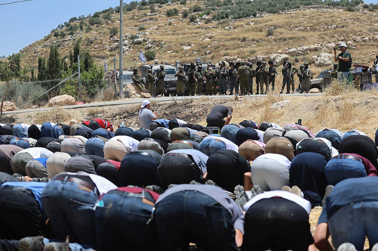 Palestinians perform Friday prayers on land threatened with confiscation in the occupied West Bank village of Idhna, June 12, 2026. (Mosab Shawer/Activestills)